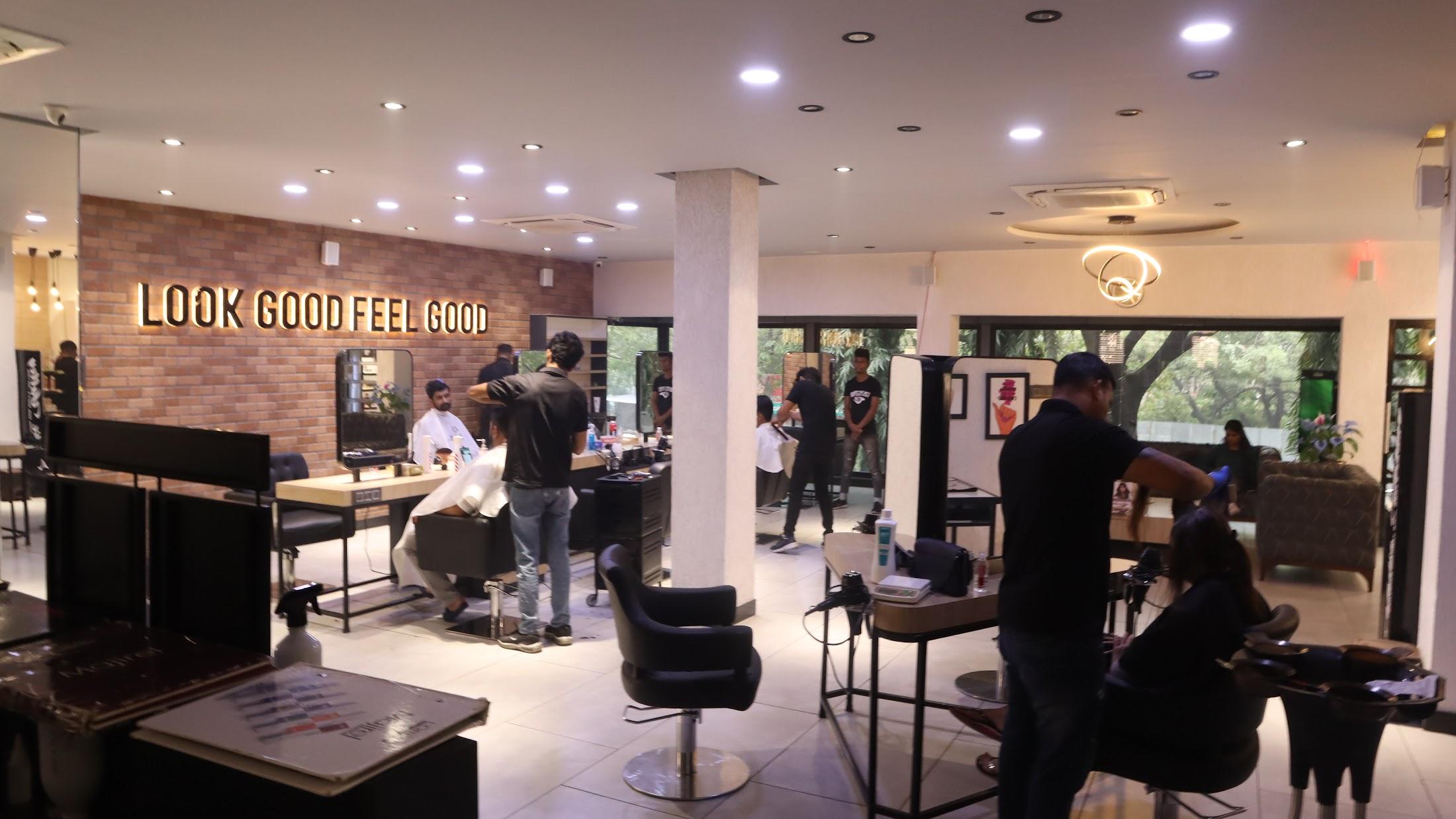 Inside Kutz The Salon — stylists at work beneath the LOOK GOOD FEEL GOOD wall